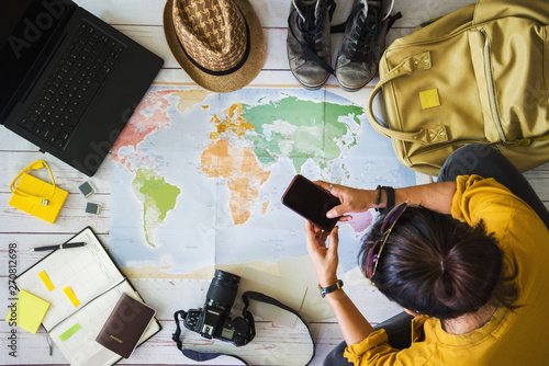 Vacation travel planning concept with map. Overhead view of equipment for travelers. Travel concept background, young Asian woman. Travel holiday, summer.