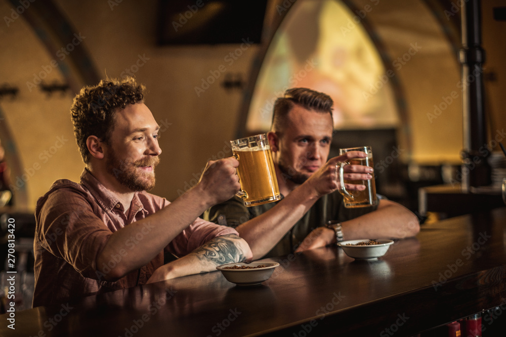 Cheerful friends drinking draft beer in a pub Cheerful friends drinking draft beer in a pub
