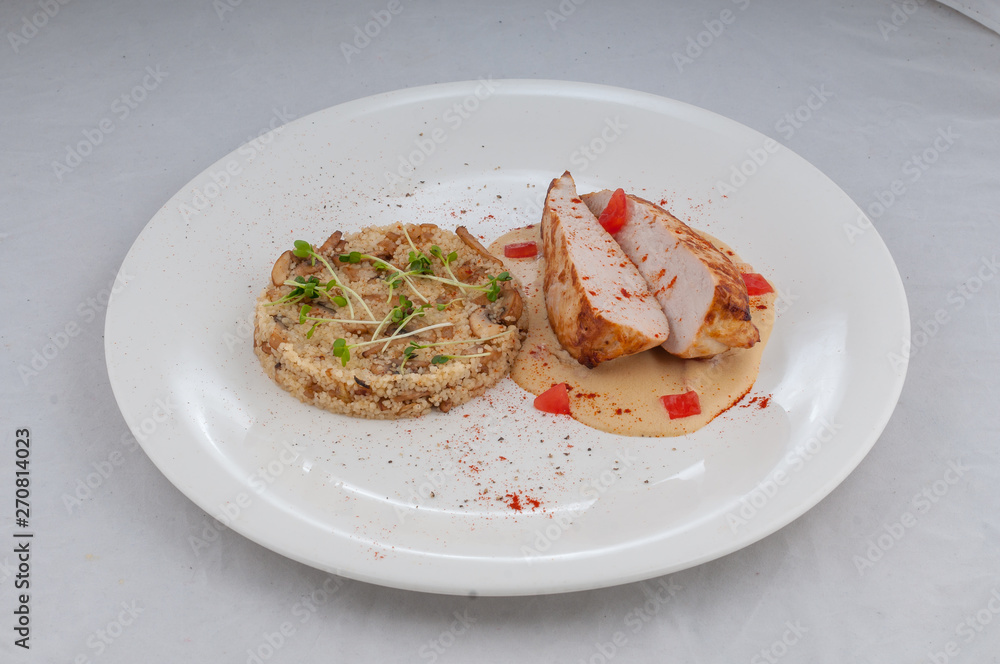 chicken with porridge in a beautiful atorsky serve from the chef on a white plate on a white background chicken with porridge in a beautiful atorsky serve from the chef on a white plate on a white background