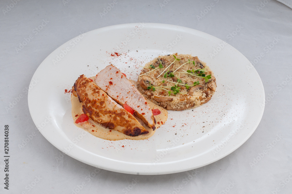 chicken with porridge in a beautiful atorsky serve from the chef on a white plate on a white background chicken with porridge in a beautiful atorsky serve from the chef on a white plate on a white background