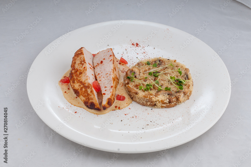 chicken with porridge in a beautiful atorsky serve from the chef on a white plate on a white background chicken with porridge in a beautiful atorsky serve from the chef on a white plate on a white background