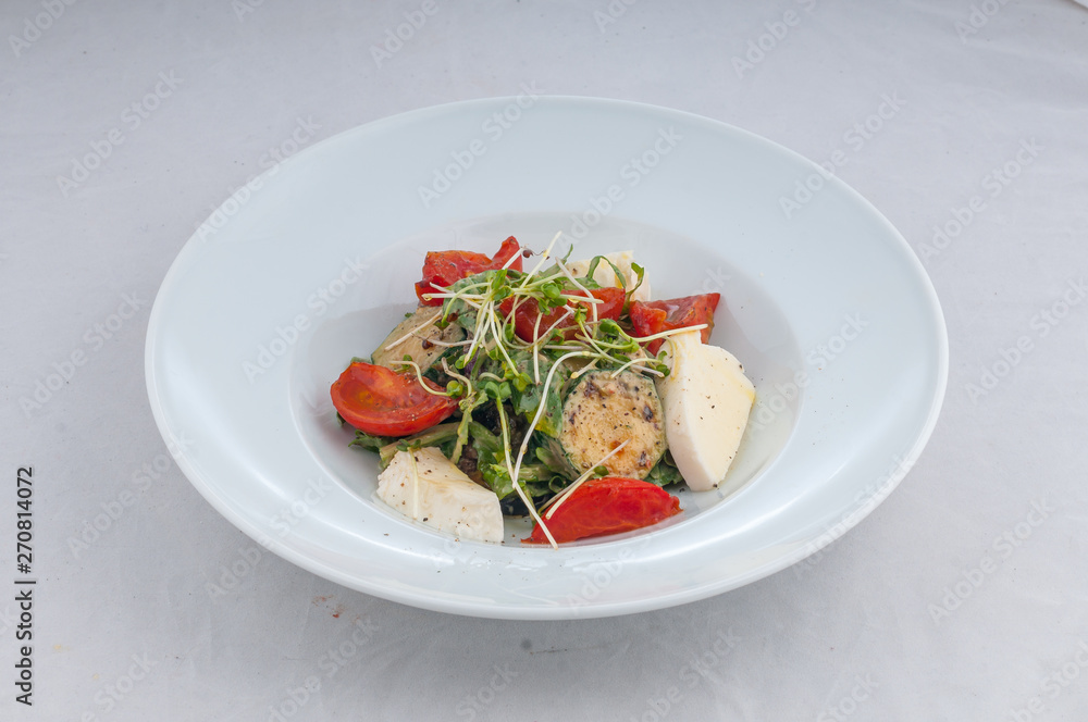 salad with cheese and grilled waxes on a white plate on a white background salad with cheese and grilled waxes on a white plate on a white background
