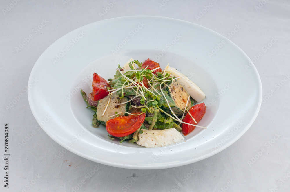 salad with cheese and grilled waxes on a white plate on a white background salad with cheese and grilled waxes on a white plate on a white background