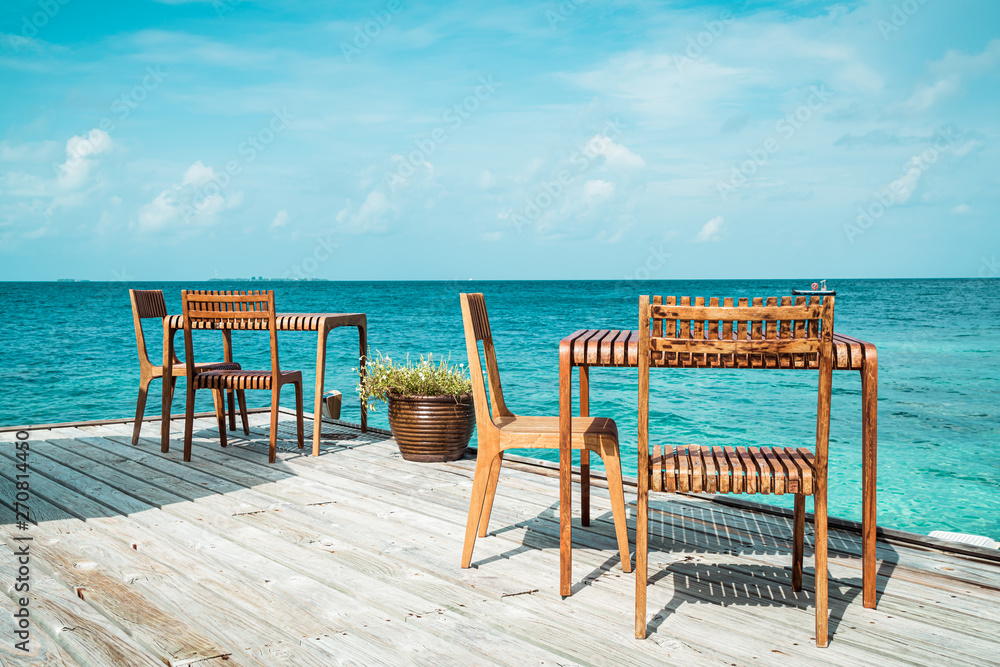 wood table and chair with sea view background in Maldives