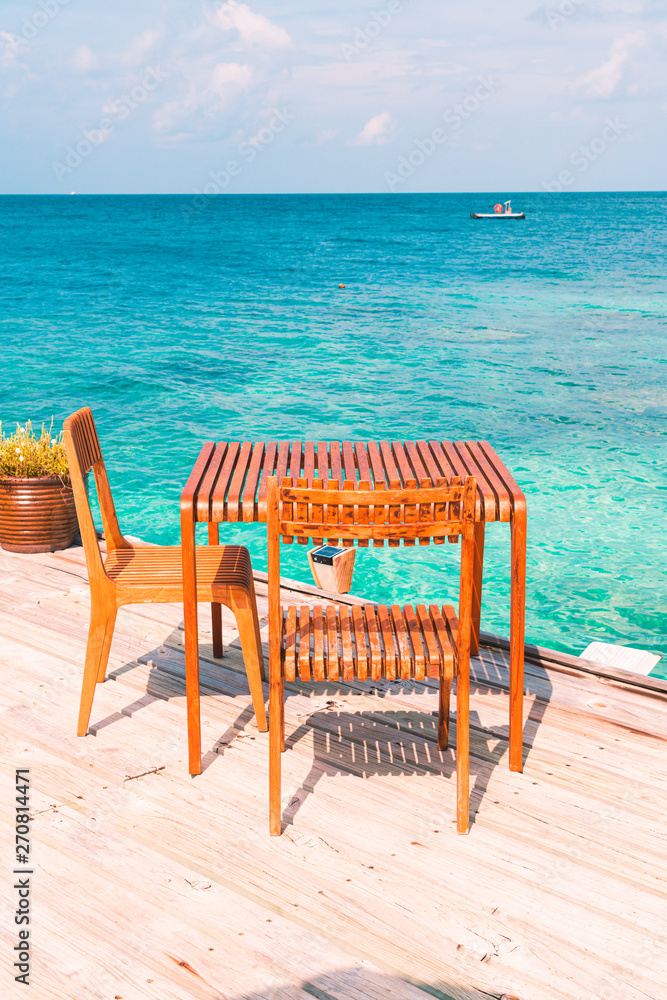 wood table and chair with sea view background in Maldives