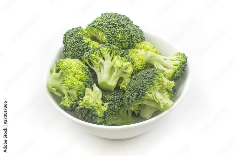 Broccoli sliced into small pieces in a white bowl Broccoli sliced into small pieces in a white bowl