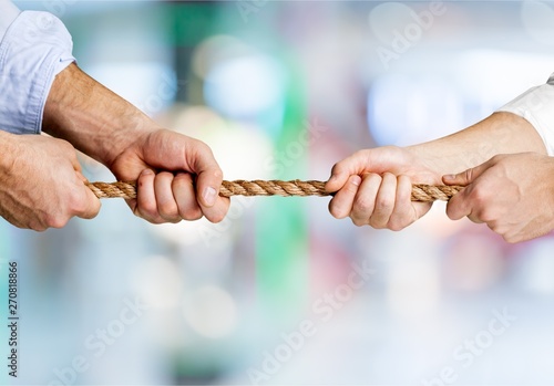 Business people pulling rope in opposite directions