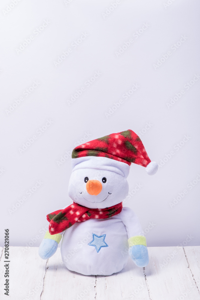Funny snowman in a red hat and scarf on a white background