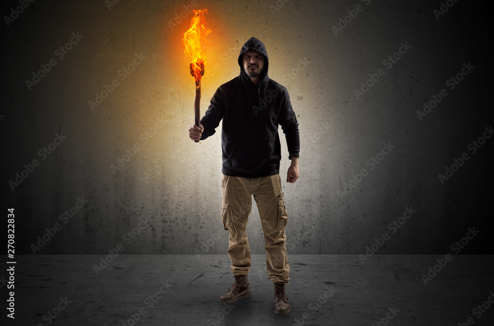 Ugly scary man with burning flambeau walking in an empty space Ugly scary man with burning flambeau walking in an empty space
