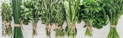 Panel kuchenny z motywem top view of various green herbs on white wooden table, panoramic shot
