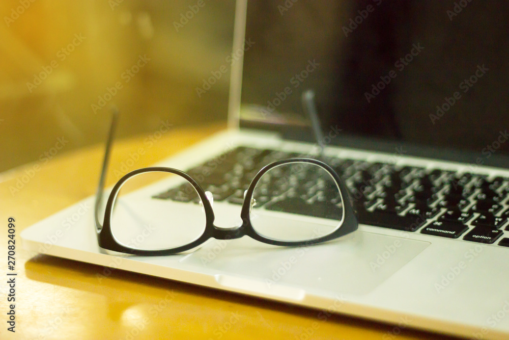 glasses and laptop on wooden desk. Lifestyle workspace. glasses and laptop on wooden desk. Lifestyle workspace.