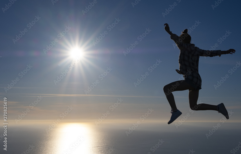 Fototapeta premium Free girl celebrated success with the sea and the sun in the background