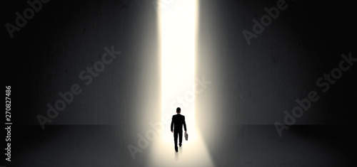 Businessman standing and seeing the light at the end of a big wall   © ra2 studio