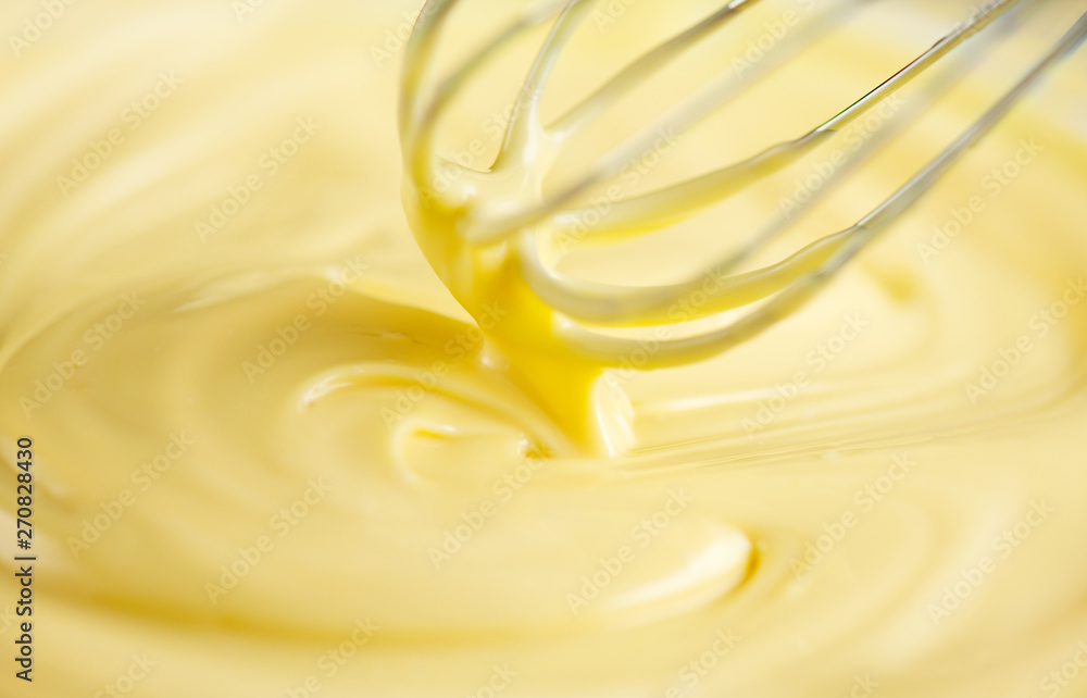 White chocolate. Melted liquid white chocolate mixing with a wisk. Closeup of molten liquid hot chocolate swirl. Confectionery White chocolate. Melted liquid white chocolate mixing with a wisk. Closeup of molten liquid hot chocolate swirl. Confectionery