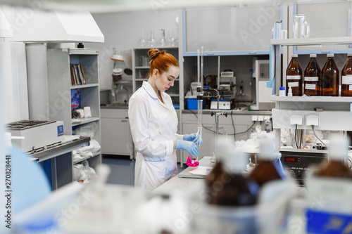 red-haired woman works in the medical laboratory