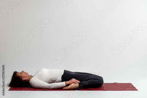 Studio shot of a woman doing yoga exercises on white background