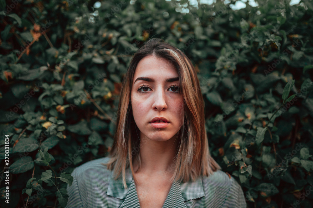 Portrait of young blond woman with plants on the background Portrait of young blond woman with plants on the background
