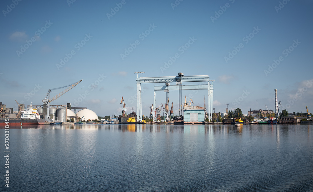 heavy cranes in port at midday from the water