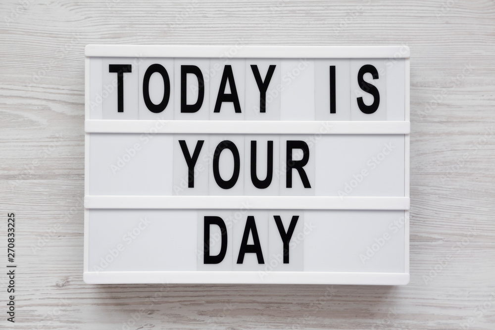 Modern board with text 'Today is your day' on a white wooden background, top view. Flat lay, overhead, from above. Close-up. Modern board with text 'Today is your day' on a white wooden background, top view. Flat lay, overhead, from above. Close-up.