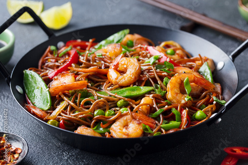 Fotografía Stir fry noodles with vegetables and shrimps in black iron pan