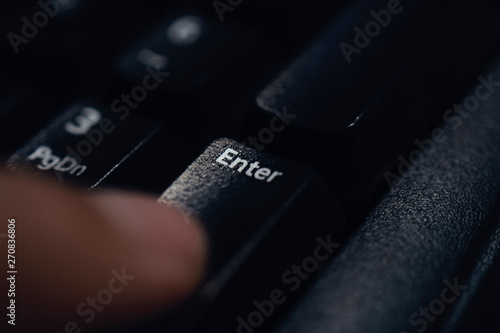 Vászonkép Finger pressing enter key close up