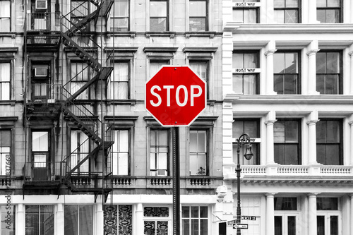 Red stop sign against background of old black and white buildings in SoHo Manhattan, New York City