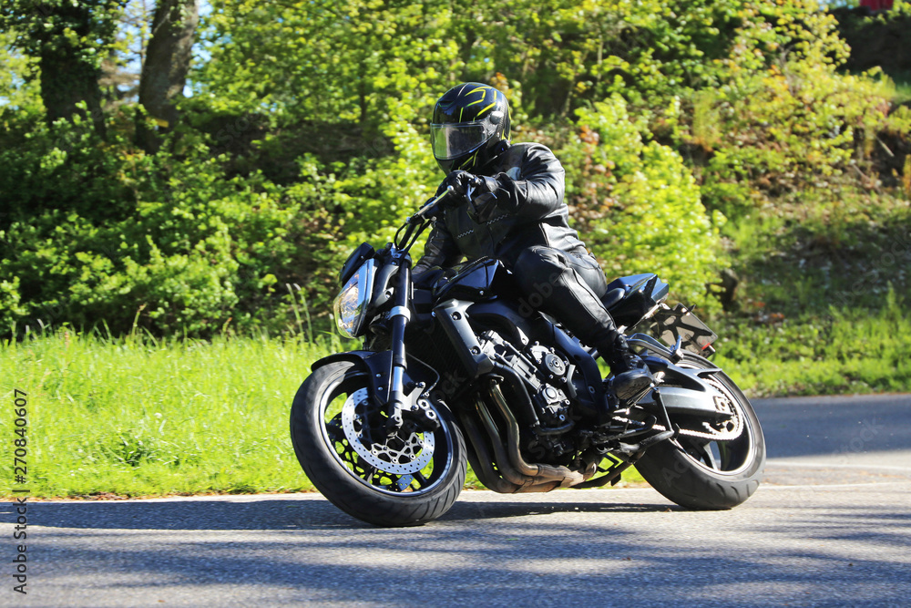 Sporting motorcyclist on a winding country road Sporting motorcyclist on a winding country road