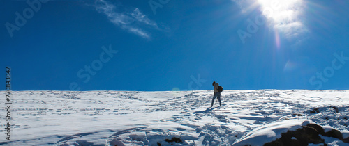 A young adult trekking across snowy landscape of Himalayas. Photo is taken during the Chandrashila summit at Uttarakhand, India. photo