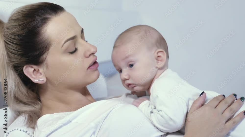 A young mother is holding her little baby boy in arms. A young mother is holding her little baby boy in arms.