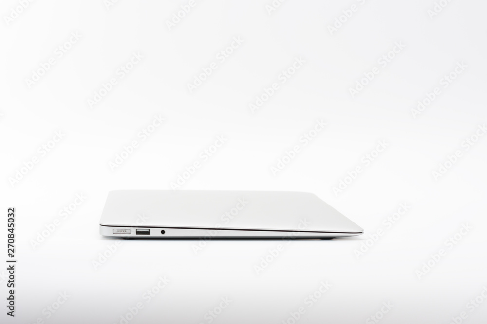 Closed modern, new laptop on white background, side view. Closed modern, new laptop on white background, side view.