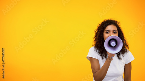 Tela Afro-American female shouting in megaphone, public relations, social opinion