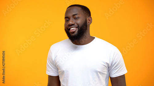 Cheerful African-American man smiling at camera isolated on yellow background
