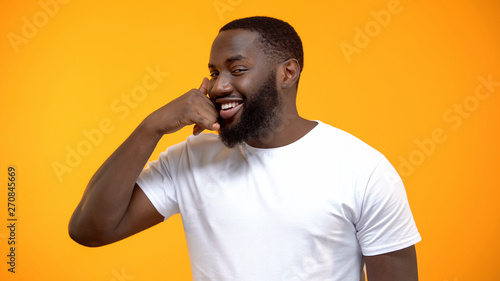 Canvastavla Cheerful Afro-American man showing call me gesture, getting acquainted on party