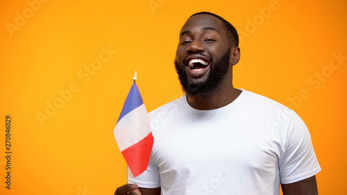 Afro-American man holding French flag on national holiday celebration, close-up