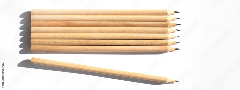 Obraz premium 8 pencils are on the table in bright daylight. Natural unpainted wood. Eco-friendly materials. Not like everyone else