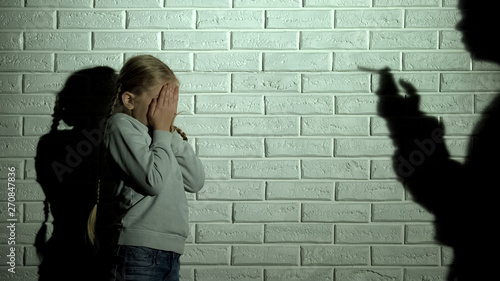 Obraz na plátně Frightened kid covering eyes, parent shadow smoking cigarette, drug addiction