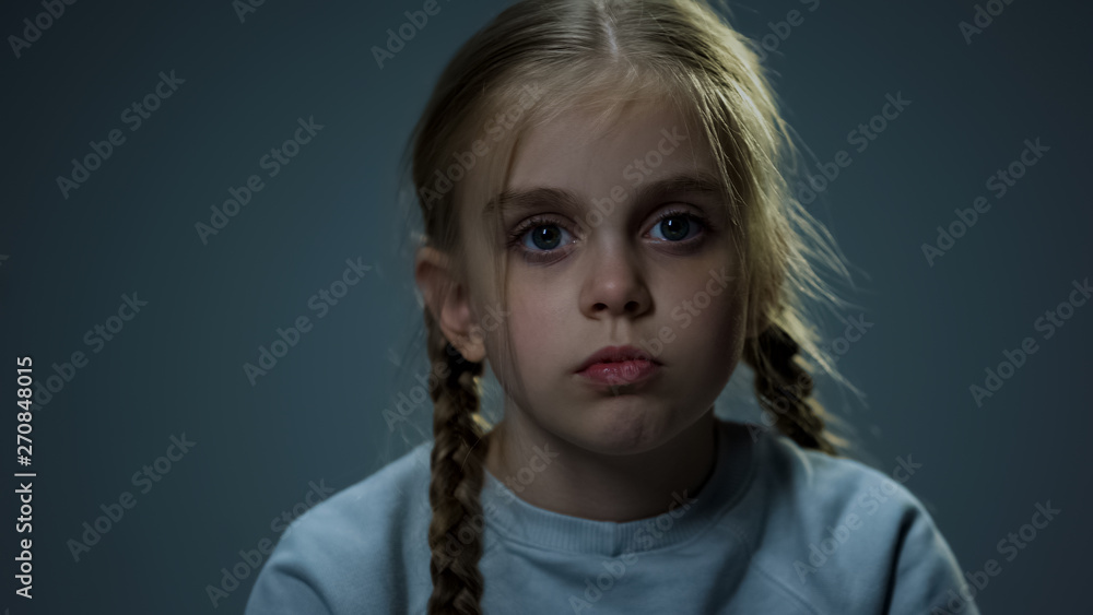 Melancholic girl looking at camera, piercing glance, child hoping for happiness Melancholic girl looking at camera, piercing glance, child hoping for happiness