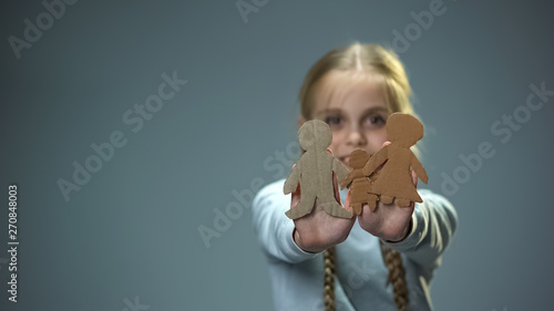 Foto Joyful child showing paper family into camera, orphan finding parents and home