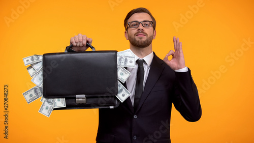 Canvas Print Male showing briefcase with money and doing ok gesture, payday lending service