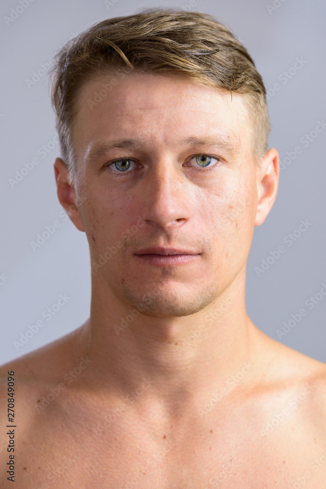 Portrait shot of young handsome Caucasian man shirtless isolated