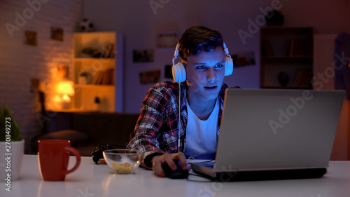 Photography Bored teenager surfing internet, eating snacks and wasting time, procrastination