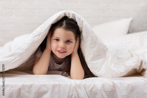 happy morning baby in bed. child dabbles in bed. child covers his ears