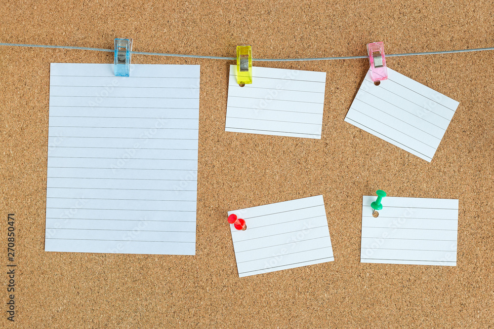 Cork memory board with blank peaces of paper hanging on rope with clothes pin and pinned on the board, horizontal Cork memory board with blank peaces of paper hanging on rope with clothes pin and pinned on the board, horizontal