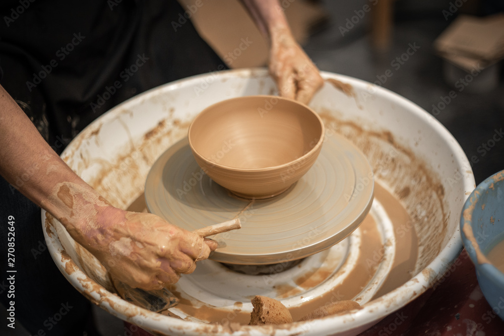 Expert potter teach a man to work on potter wheel Expert potter teach a man to work on potter wheel
