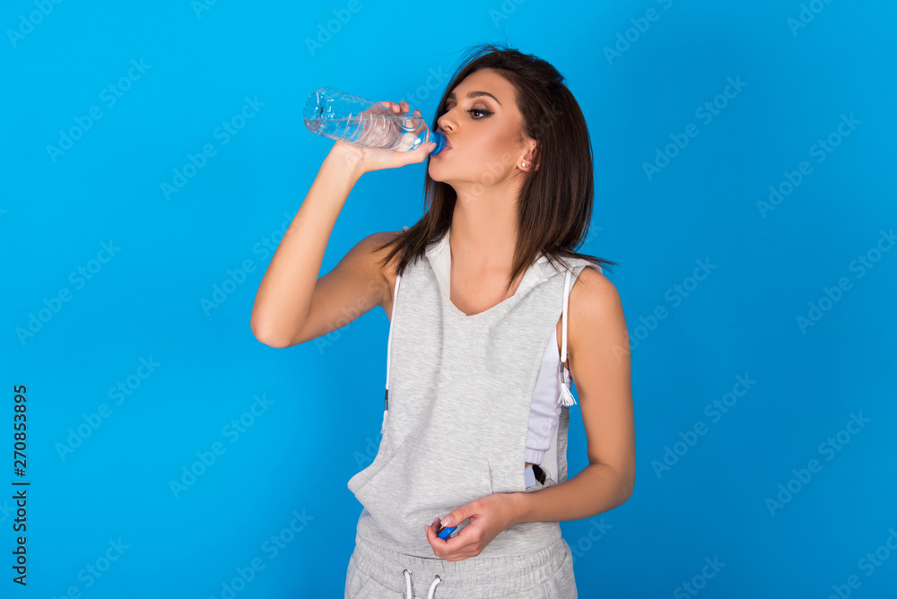 Beautiful teen girl holding bottle of water, smiling and drinking fresh water Beautiful teen girl holding bottle of water, smiling and drinking fresh water