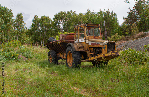 Old, rusty, yellow and abandoned dumper.