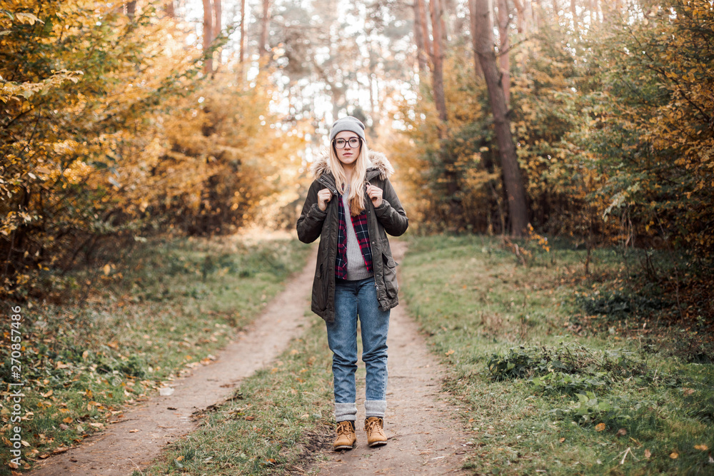 Hiking and travel along in the forest. Concept of trekking, adventure and seasonal vacation. Young woman walking in woods. Hiking and travel along in the forest. Concept of trekking, adventure and seasonal vacation. Young woman walking in woods.