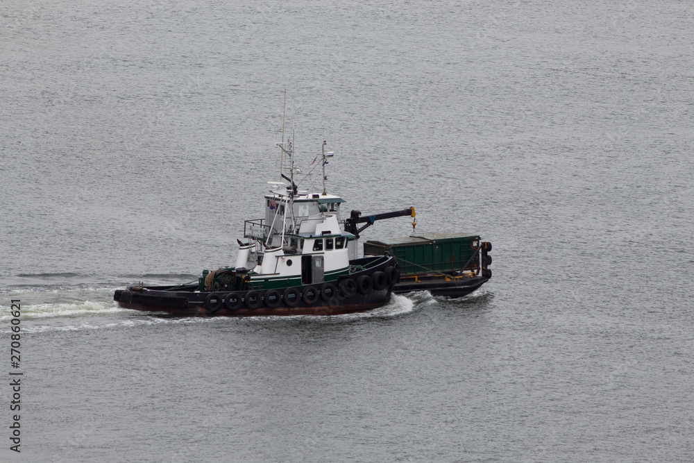 Green ship on the ocean with a crane and a cargo box Green ship on the ocean with a crane and a cargo box