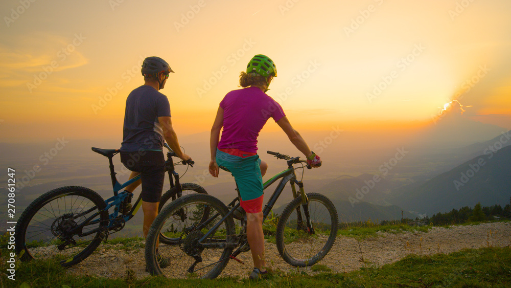 COPY SPACE: Mountain bikers sit on their bikes and watch the beautiful sunset.