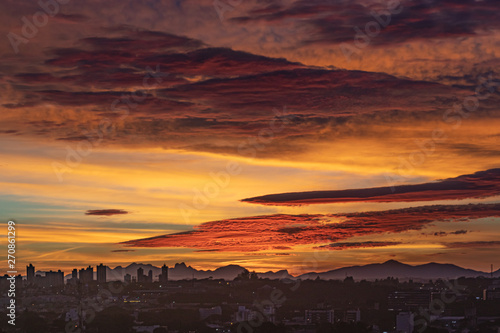 Colorful sunrise over the city and the mountain range